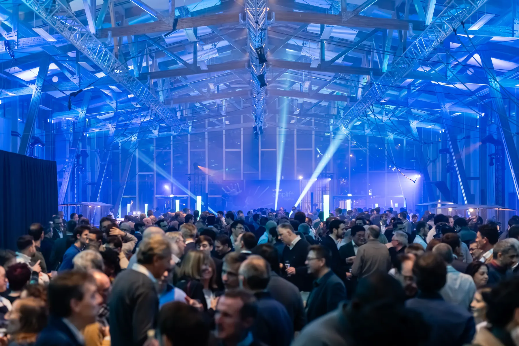 Les invités échangent pendant un cocktail de networking dans un hall bleu