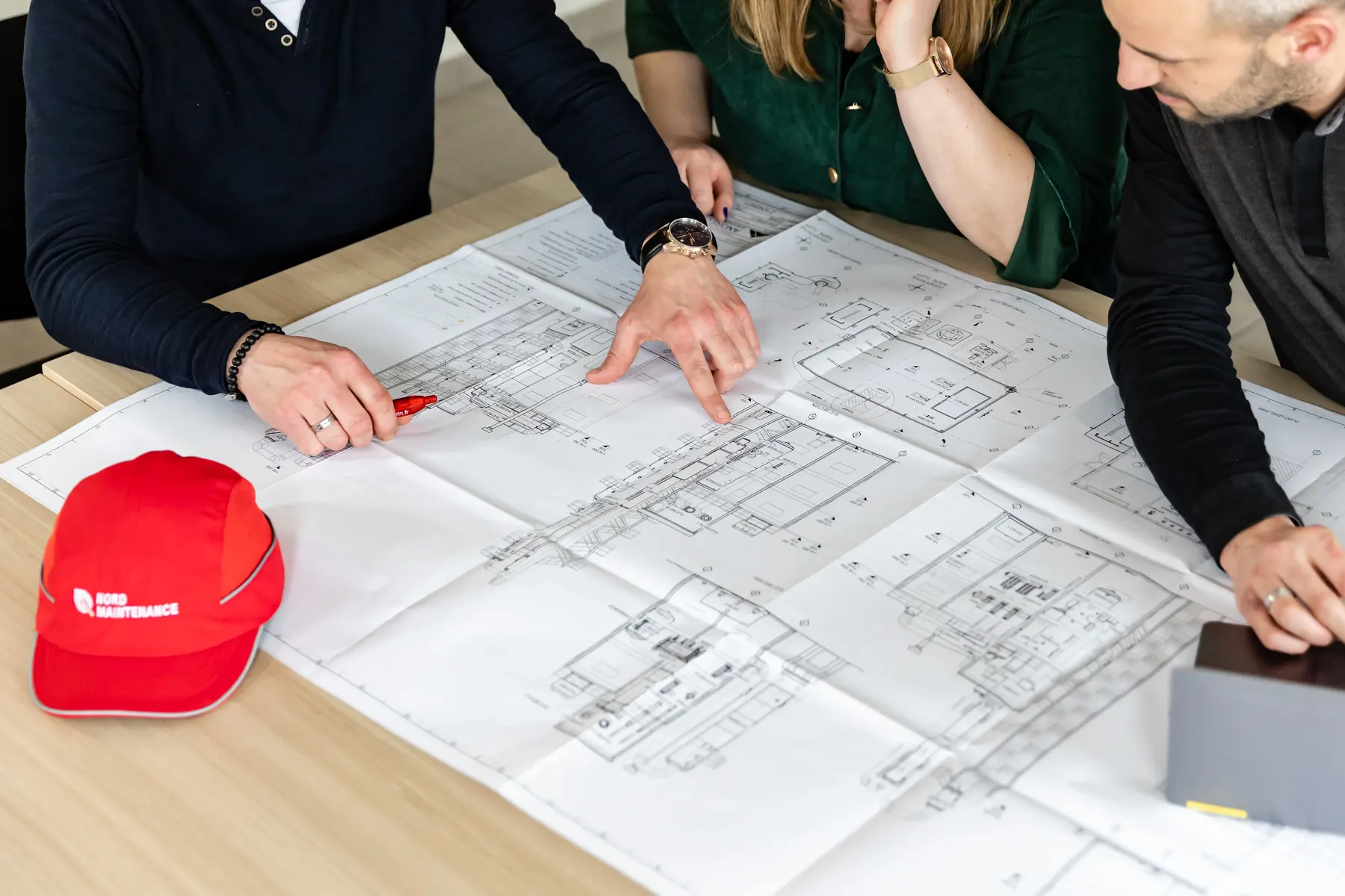 Equipe d’ingénieurs lisant des plans techniques sur table pour le brief